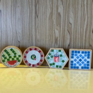 孩子將彩色馬賽克方塊拼成杯墊花紋
